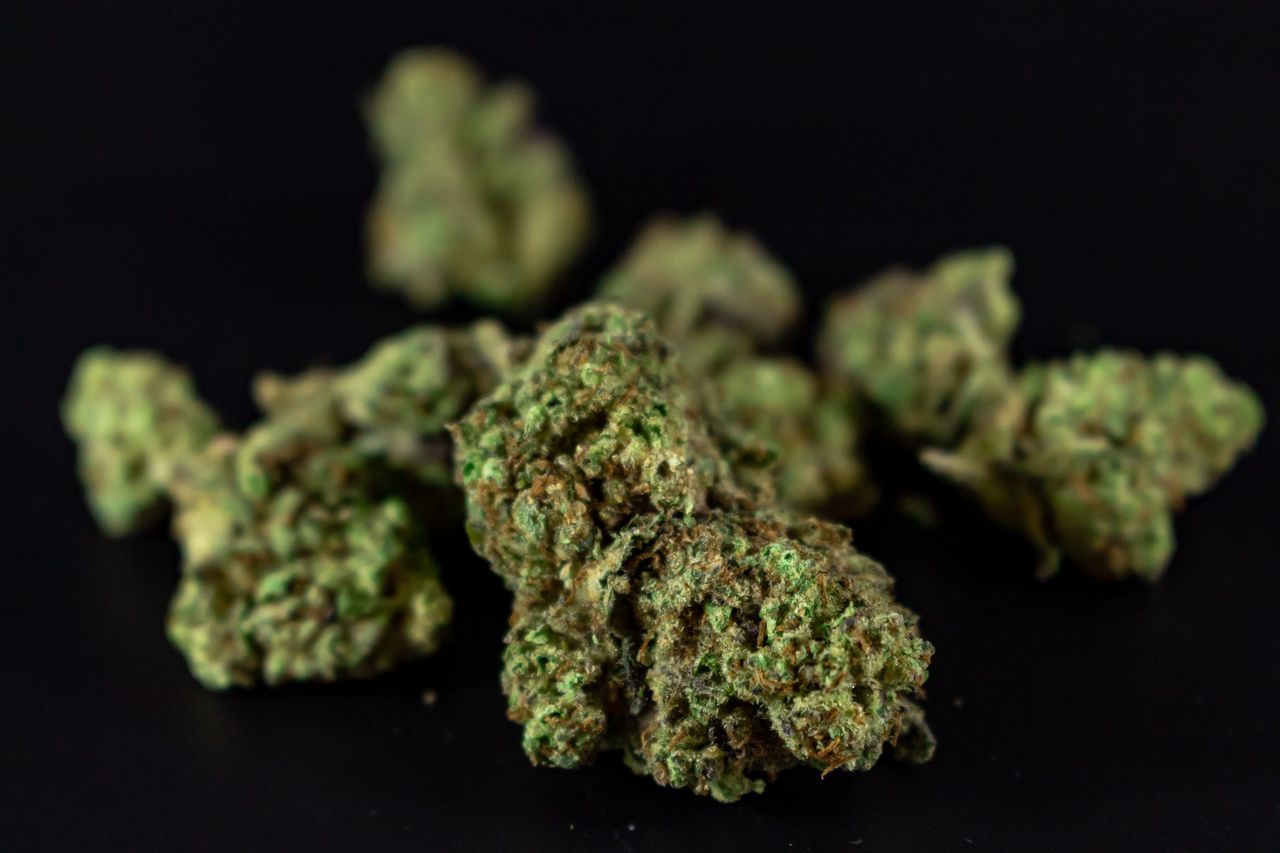 High-quality close-up image of cannabis buds against a dark background.